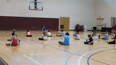 Kids stretching on gym floor