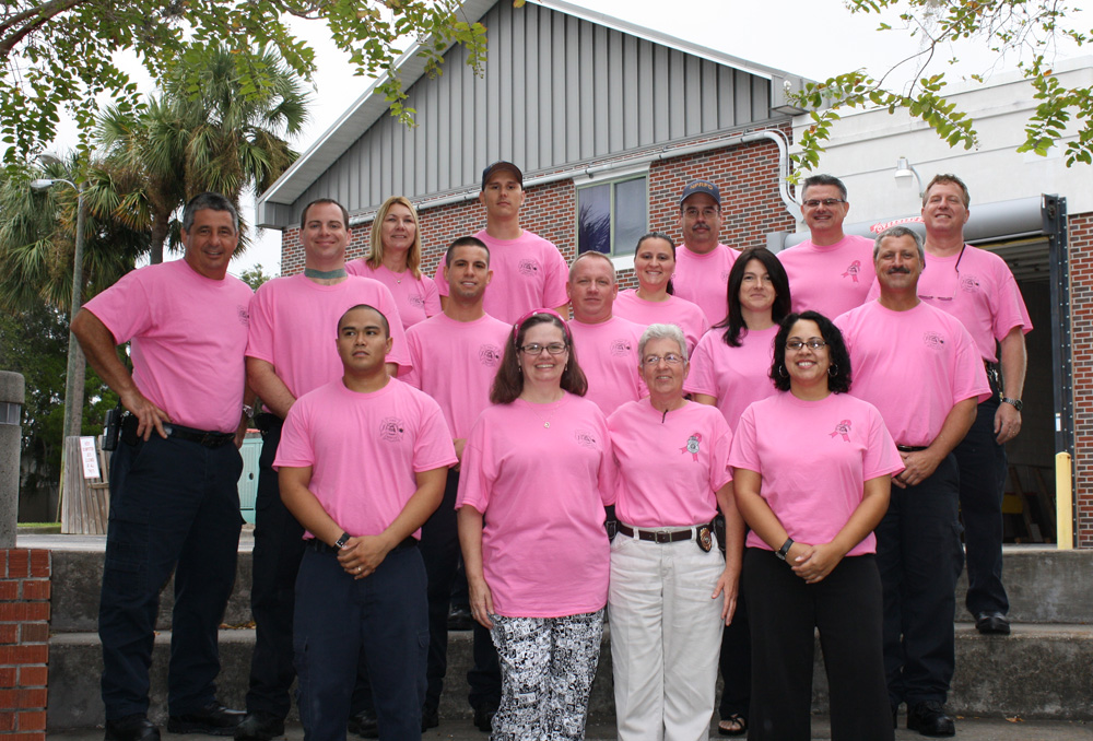 Several people wearing pink shirts on an exterior staircase