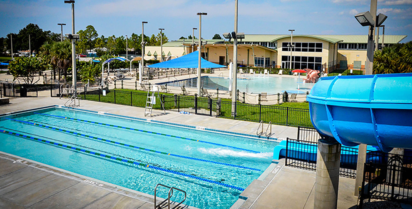 Elevated view of two pools behind the Recreation and Aquatic Center on a sunny day.
