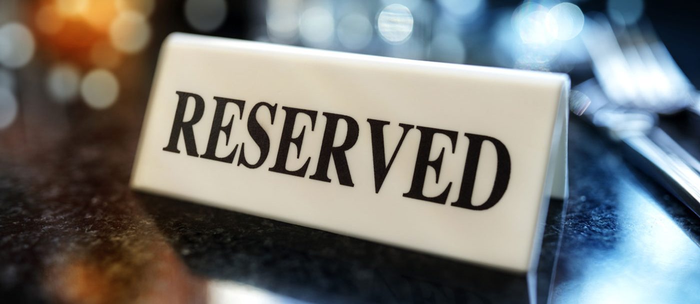 A placard that reads "reserved". Out of focus silverware in the background.
