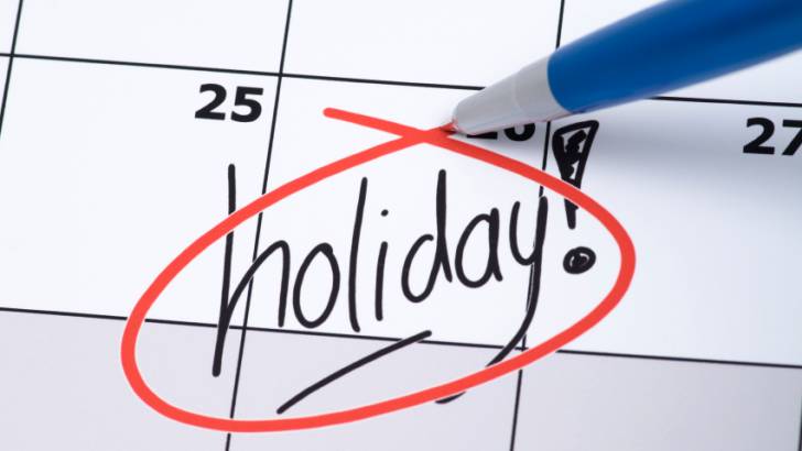 A blotter monthly calendar with the 26th, 27th, and 28th days visible. The word "holiday!" is written on the 26th and is being circled in red by a pen.